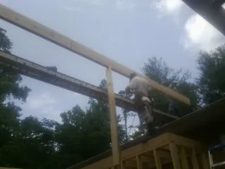 Carpenter setting a ridge beam over a new addition frame — Ice Dam Removal by Roofing Brothers in Thompsons Station