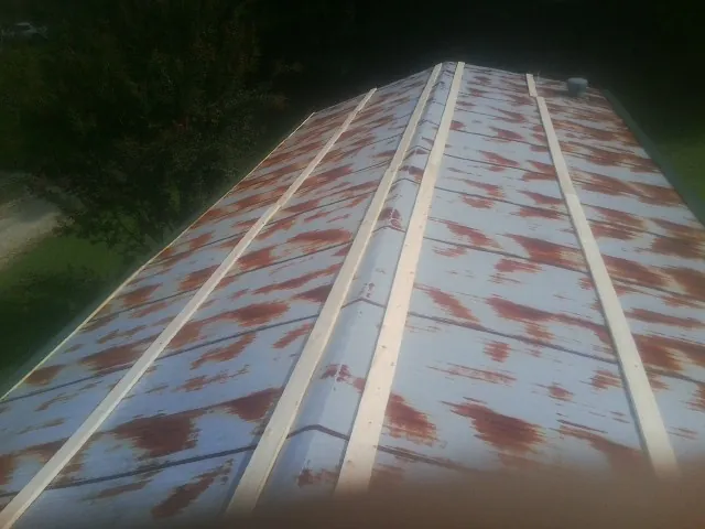 Rusted metal roof panels with new wood purlins before replacement — Storm Damage Roof Repair in Thompsons Station by Roofing Brothers