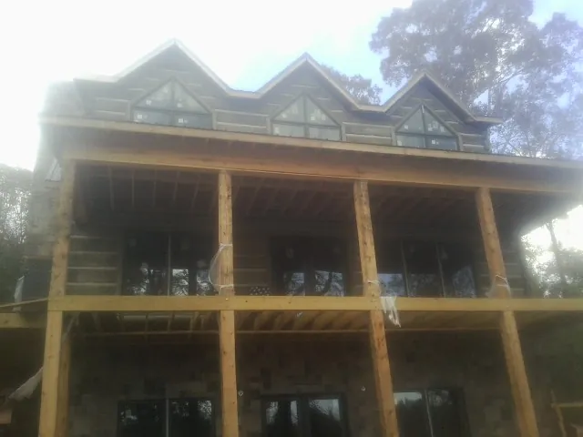 Dormers and porch framing on a large log home under construction — Roof Coating work by our crew in Thompsons Station