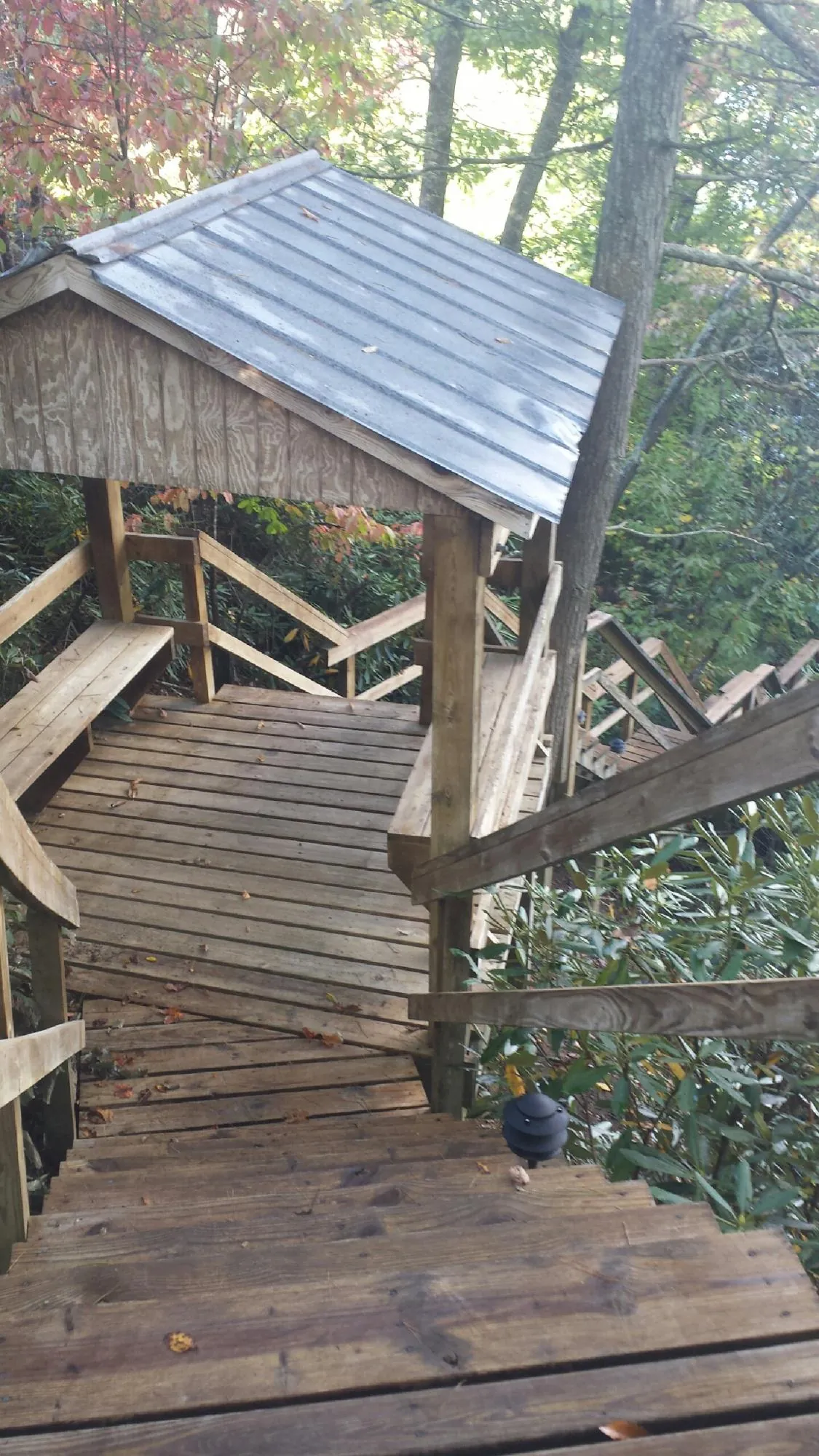 Metal roofed shelter over wooden steps on a wooded walkway — Skylight Repair & Installation work by our crew in Thompsons Station