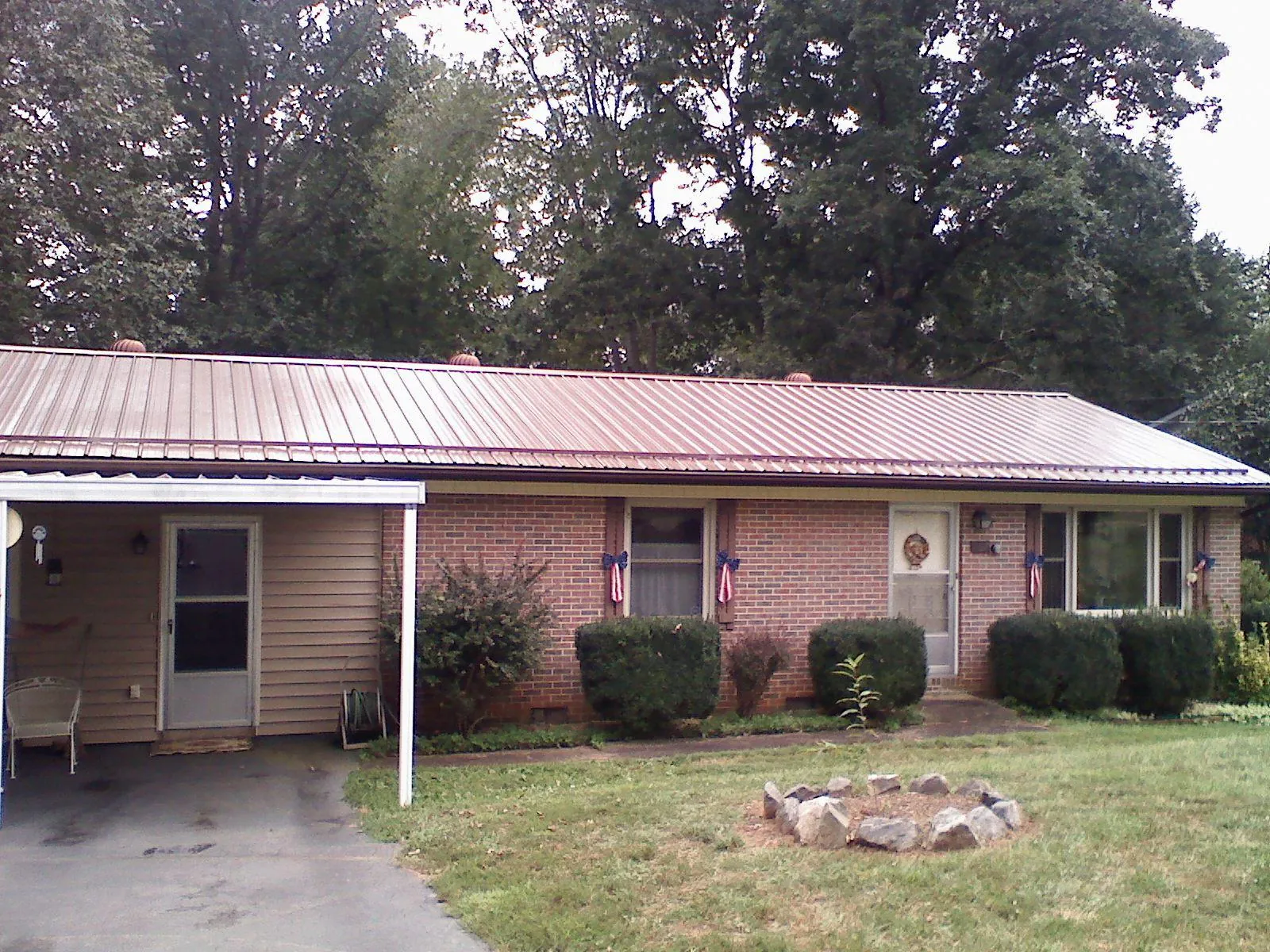 Bronze metal roof and carport on a brick ranch home — Roof Repair work by our crew in Thompsons Station